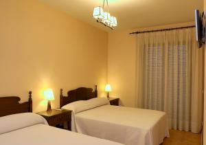拉耶斯萨尔瓦多特哈尔乡村旅馆的一间卧室设有两张床、两盏灯和一个窗户。