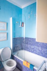 洛思坎加约斯Mar y Sol的蓝色瓷砖浴室设有卫生间和浴缸