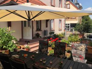 美茵河畔哈瑙LUXURY NEAR FRANKFURT 8 PERSON 24 7 CHECK的一个带桌子和遮阳伞的庭院