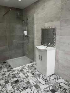 瓦伦西亚岛Blue Cottage的带淋浴、盥洗盆和镜子的浴室