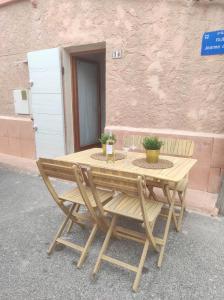 马赛Chill Out Cabanon Coeur Calanques的一张木桌,旁边是一座建筑,配有两把椅子