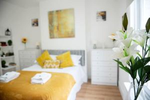 剑桥King's Central Cambridge Apartment的一间卧室配有黄色和白色枕头的床