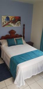 蒙特哥贝Melrose Place的一间卧室配有蓝色和白色的床