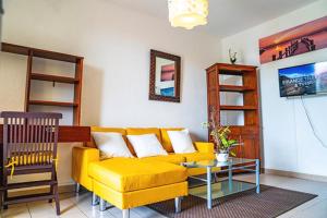 库鲁Bel appartement T2 * Netflix * Terrasse* Parking的客厅配有黄色的沙发和桌子