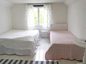 HallabroHoliday home HALLABRO IV的一间白色卧室,配有两张床和窗户