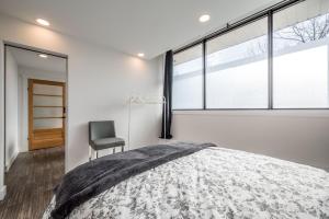 哈利法克斯Modern Contemporary 2 Bedroom Suite的一间卧室配有一张床、一把椅子和窗户。