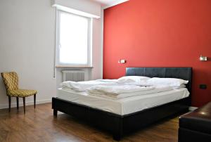 加尔达湖滨Riva City View的一间卧室配有一张红色墙壁的床