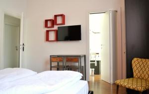加尔达湖滨Riva City View的卧室配有一张床,墙上配有电视