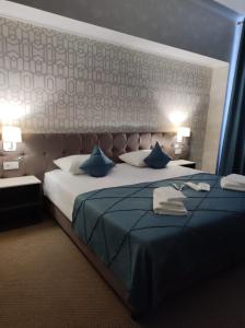 库斯塔奈De Marco Hotel的一间卧室配有一张带蓝色枕头的大床