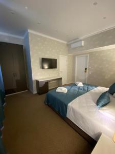 库斯塔奈De Marco Hotel的酒店客房设有两张床和一台平面电视。