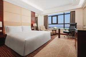 顺义北京临空皇冠假日酒店的酒店客房设有一张白色大床和一张书桌