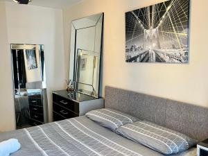 哈洛Radiant2 bedroom apartment in the heart of Harlow town的一间卧室配有一张床、梳妆台和镜子