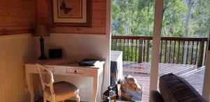 默立基Kookas Cottage的客房设有书桌和带门廊的阳台