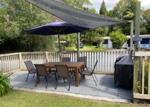 凯里凯里殖民别墅汽车旅馆的庭院里配有桌椅和遮阳伞