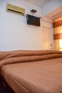 库鲁内格勒Janara Two的卧室配有一张床铺,墙上配有电视