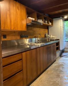 KalawanaKurunduketiya Private Rainforest Resort的一个带水槽和木橱柜的厨房