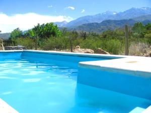 波特雷里约斯Las Espuelas Casas de Montaña的一座蓝色的游泳池,后面是群山
