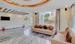 达兰萨拉Treebo Trend Ortus Residency的带沙发和电视的客厅