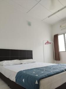 彭亨文冬窝心民宿的一间卧室配有一张带蓝色毯子的大床