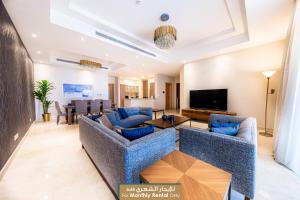 吉达Mabaat - Obhour - 358的客厅配有蓝色的沙发和平面电视。