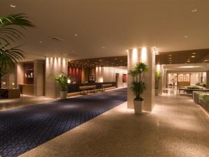 静冈阿索西亚静冈酒店(Hotel Associa Shizuoka)的楼里种植盆栽的大堂