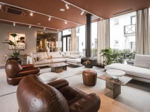 栋堡Strandhotel Domburg的客厅配有皮革家具和大窗户