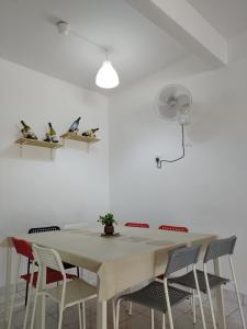 彭亨文冬窝心民宿的白色的餐桌、椅子和风扇