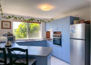 科夫斯港On the Hillside的厨房配有蓝色橱柜和白色冰箱