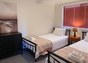 科夫斯港On the Hillside的一间卧室设有两张床和窗户。