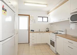 萨维特尔Ocean Sands 5的厨房配有白色橱柜和白色冰箱。