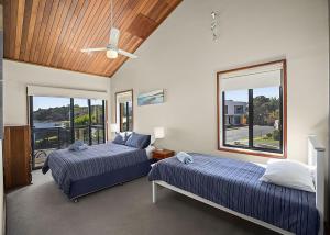 萨维特尔Peninsula的一间卧室配有两张床和吊扇