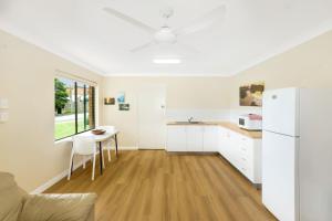萨维特尔Peninsula的白色的厨房配有桌子和冰箱