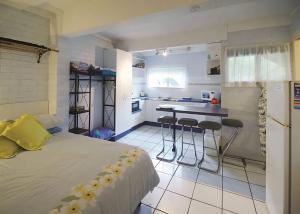 楠巴卡黑兹Pacific Studio的一间卧室配有一张床和一个小厨房