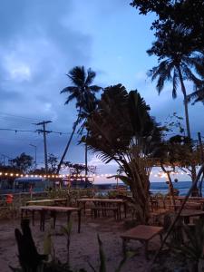 沙璜Casa Leonora的海滩上设有野餐桌,晚上种植棕榈树