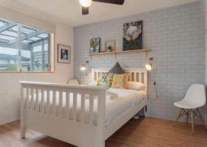 萨维特尔Lemongrass的白色的婴儿床,卧室内有白色的砖墙