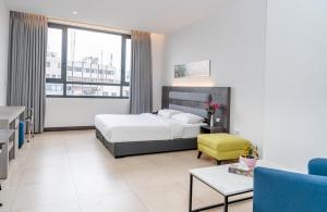 安曼Liv Weibdeh Hotel Suites的一间卧室设有一张床和一间客厅。