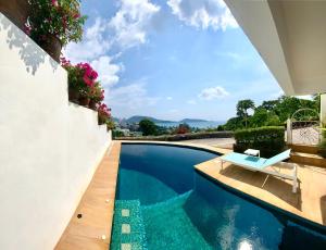 芭东海滩Andaman Hill Pool Seaview的房屋旁带长凳的游泳池