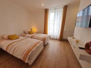 LétricourtGuestroom Létricourt, 2 pièces, 4 personnes - FR-1-584-197的一间卧室设有两张床、一台电视和一扇窗户。