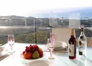 Kororo BasinBelvedere的一张桌子,上面放着一盘水果和一瓶葡萄酒
