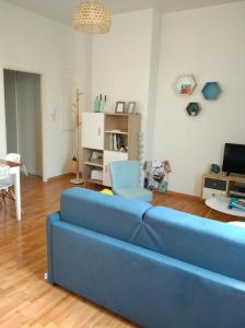 索米尔Appartement calme proche de la Loire的客厅配有蓝色的沙发和椅子