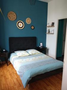 索米尔Appartement calme proche de la Loire的一间卧室配有一张蓝色墙壁的床