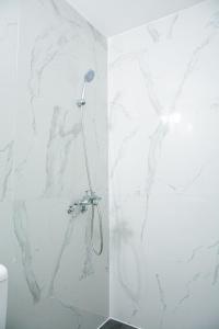 安吉利斯Maganda hotel的一间设有白色大理石墙壁和淋浴的浴室