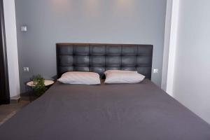 弗洛里纳Florina Sky Loft的一张带黑色皮革床头板的床和两个枕头