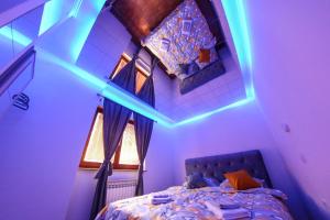 萨拉热窝Hedonist Spa Apartment的一间卧室配有一张蓝色灯光的床