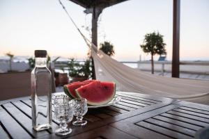 干尼亚Diotima - Astonishing seaview的桌上的西瓜片,带一瓶酒和眼镜