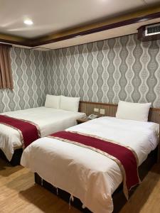 高雄梅花大饭店的酒店客房带两张床和一面墙