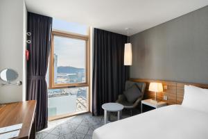 蔚山Staz Hotel Ulsan的酒店客房设有床和窗户。