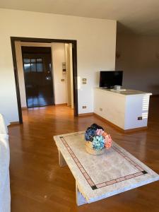 安德里亚Appartamento con veranda Via Castel del Monte的客厅配有带花瓶的桌子
