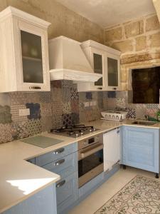 沙拉Ta' Tereza的厨房配有白色橱柜和炉灶烤箱。