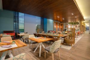 圣萨尔瓦多Hyatt Centric San Salvador的餐厅设有木桌、椅子和窗户。